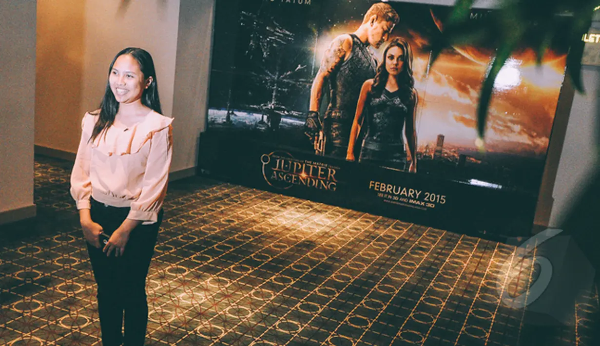 Seorang pengunjung berpose di dekat poster fIlm Jupiter Ascending saat Premier Film Jupiter Ascending di Plaza Indonesia XXI, Jakarta, Selasa (3/2/2015). (Liputan6.com/Faizal Fanani)