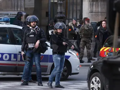 Petugas berjaga-jaga di sekitar Museum Louvre, Perancis, Jumat (3/2). Seorang pria dilaporkan berupaya menyerang seorang tentara Prancis di dekat galeri seni terkenal di Paris, Le Louvre.(AP Photo/Thibault Camus)