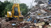 Alat berat membongkar reruntuhan bangunan PHD untuk mempermudah polisi melakukan olah TKP, Kota Bekasi, Minggu (23/10). Satu unit eskavator milik Dinas Bina Marga dan Tata Air Kota Bekasi dipinjamkan ke lokasi ledakan. (Liputan6.com/Yoppy Renato)