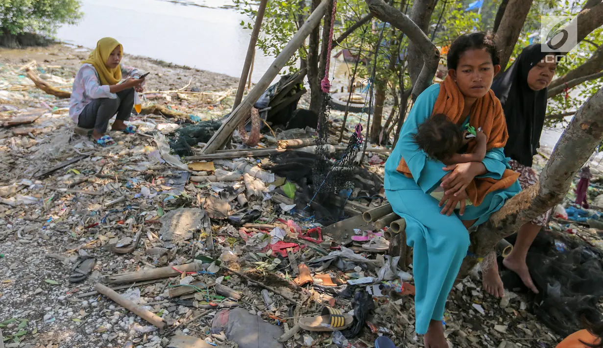 Warga yang memilih bertahan akibat abrasi bersantai di Desa Pantai Mekar, Kecamatan Muara Gembong, Bekasi, Kamis (20/6/2019). Puluhan rumah warga di Kampung Muarajaya RT01/RW01 Desa Pantai Mekar hilang tersapu air saat terjadi abrasi selama 10 tahun. (Liputan6.com/Fery Pradolo)