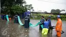 Petugas Suku Dinas Tata Air menarik selang pembuangan saat melakukan penyedotan air banjir di Jalan Gunung Sahari, Jakarta, Selasa (21/2). Hujan yang mengguyur sejak Selasa dinihari membuat sebagian wilayah di Jakarta banjir. (Liputan6.com/Faizal Fanani)