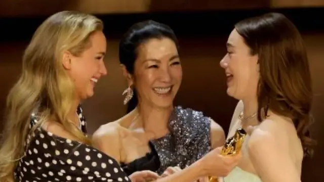 Penyerahan Piala Oscar kepada Emma Stone oleh Michelle Yeoh dan Jennifer Lawrence. [Foto: Instagram/michelleyeoh_official]