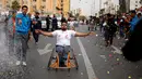 Peserta melakukan selebrasi usai mencapai garis finis dalam perlombaan kursi roda di Kota Gaza, (29/11). Lomba ini diselenggarakan untuk para warga yang mengalami cacat fisik akibat konflik sejak tahun 2008 dengan militer Israel. (REUTERS/Suhaib Salem)