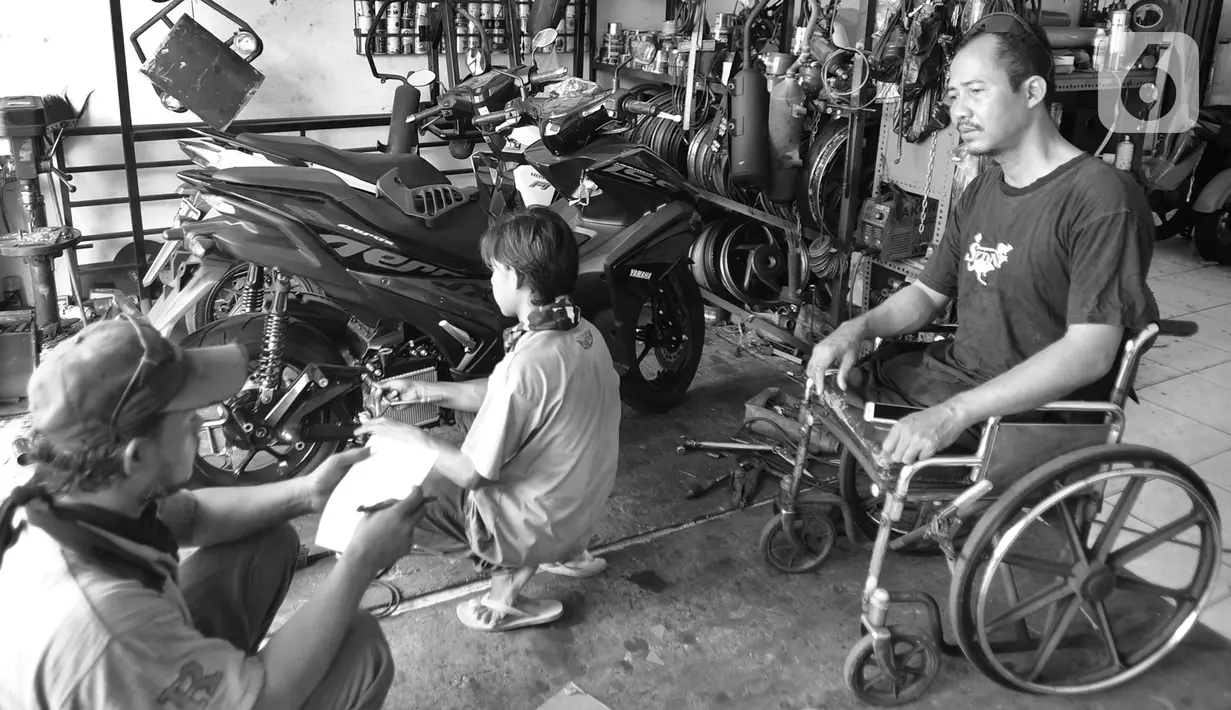 Penyandang disabilitas Catur Bambang (45) berbincang saat menyelesaikan pembuatan sepeda motor roda tiga di bengkelnya, Jalan Wijaya Kusuma, Ciputat Timur, Tangerang Selatan, Banten, Selasa (5/11/2019). Catur mampu membuat 2-3 sepeda motor roda tiga dalam seminggu. (merdeka.com/Arie Basuki)