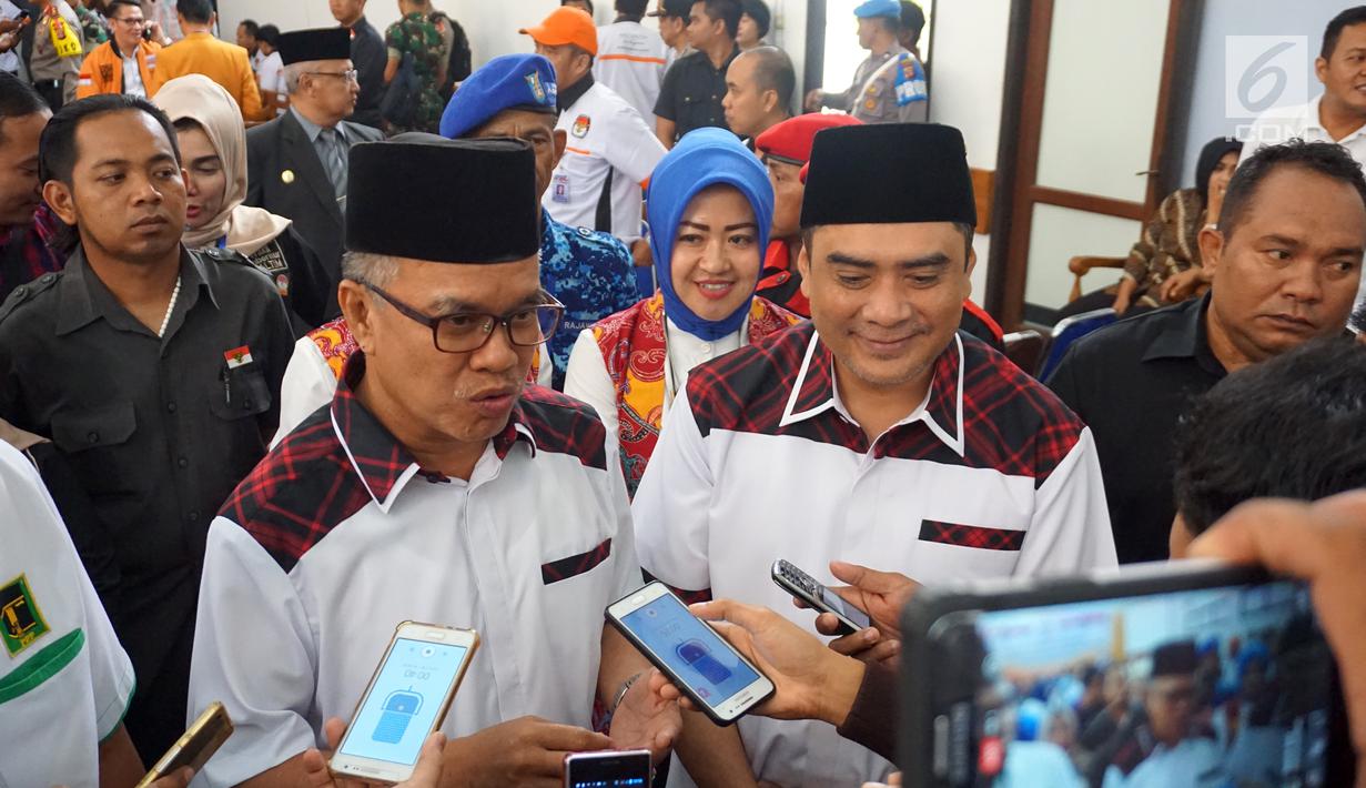 Cagub dan cawagub Kalimantan Timur Syaharie Jaang dan Awang Ferdian Hidayat menjawab pertanyaan wartawan usai penetapan oleh KPU Kaltim di Samarinda, Senin (12/2). Pasangan ini diusung oleh Demokrat, PKB, dan PPP. (Liputan6.com/Maulana)