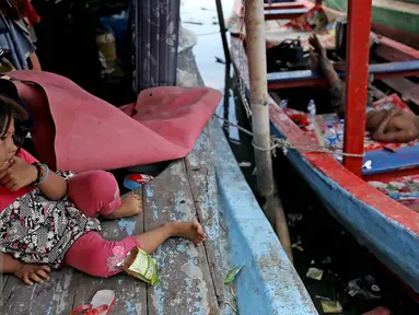 Seorang anak duduk di atas kapal pasca penggusuran permukiman Pasar Ikan, Jakarta, Selasa (13/4/2016). Warga Pasar Ikan mengaku belum mendapat rumah susun sewa yang telah dijanjikan oleh Pemprov DKI Jakarta. (Liputan6.com/Faizal Fanani)