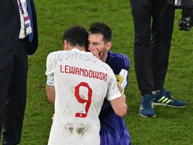 Penyerang Polandia #09 Robert Lewandowski dan penyerang #10 Argentina Lionel Messi saling menyapa pada akhir matchday pamungkas Grup C Piala Dunia 2022  di 974 Stadium, Kamis (1/12/2022) dini hari WIB. Di akhir laga, ada momen menarik saat dua pemain bintang, Lionel Messi dan Robert Lewandowski saling berdiskusi. (Glyn KIRK / AFP)