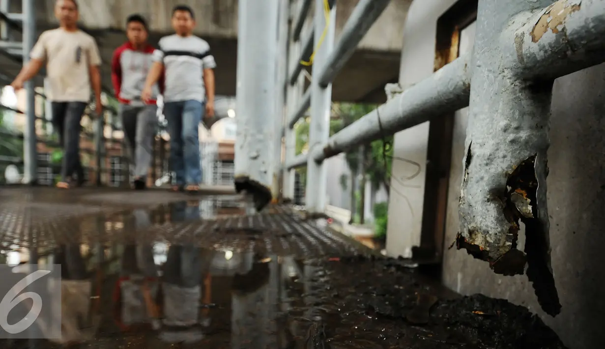 Pejalan kaki melintas di Jembatan Penyeberangan Orang (JPO) di Jalan Iskandarsyah, Jakarta, Selasa (1/11). Tampak tiang besi penyangga JPO yang berkarat terlepas termakan cuaca dan usia. (Liputan6.com/Helmi Fithriansyah)