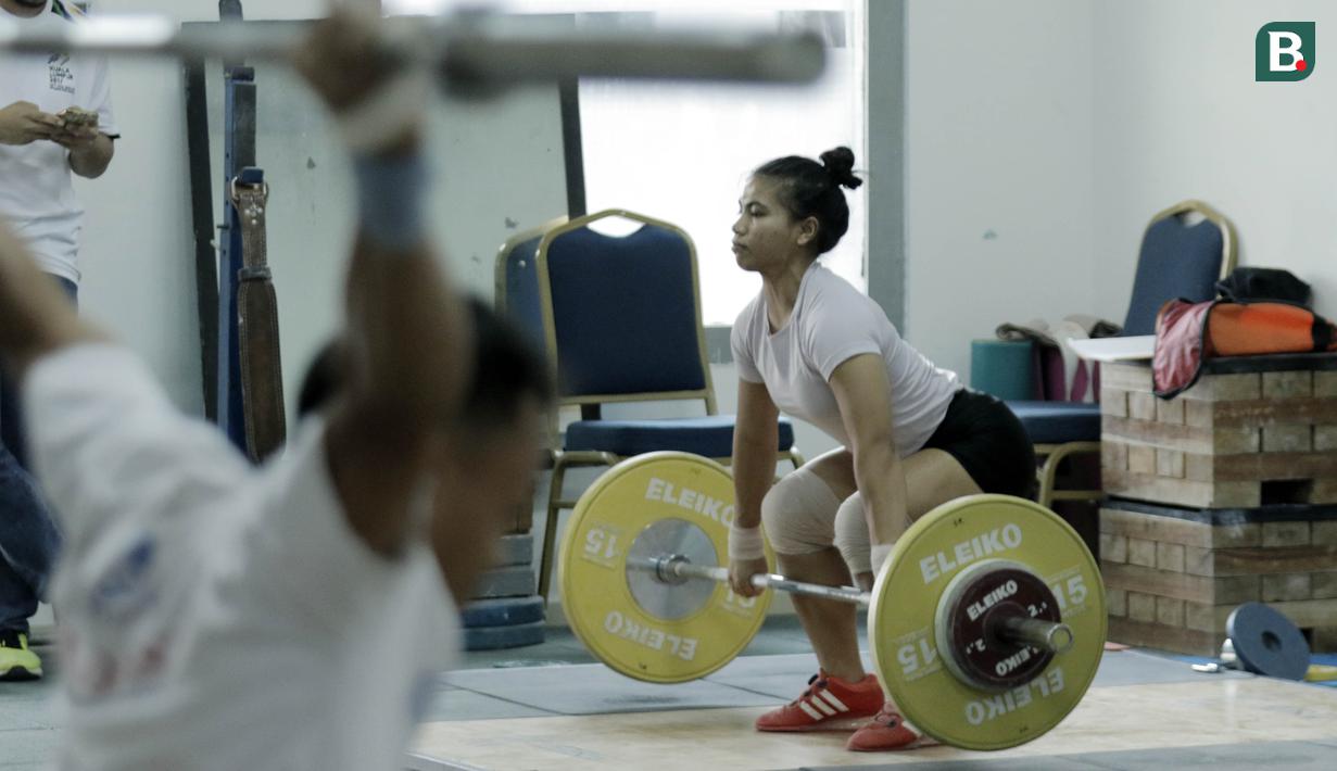 Atlet angkat besi, Sri Wahyuni, saat latihan di Wisma Kwini, Jakarta, Senin, (12/6/2018). Para lifter perempuan Indonesia terus melakukan persiapan jelang Asiang Games 2018. (Bola.com/M Iqbal Ichsan)