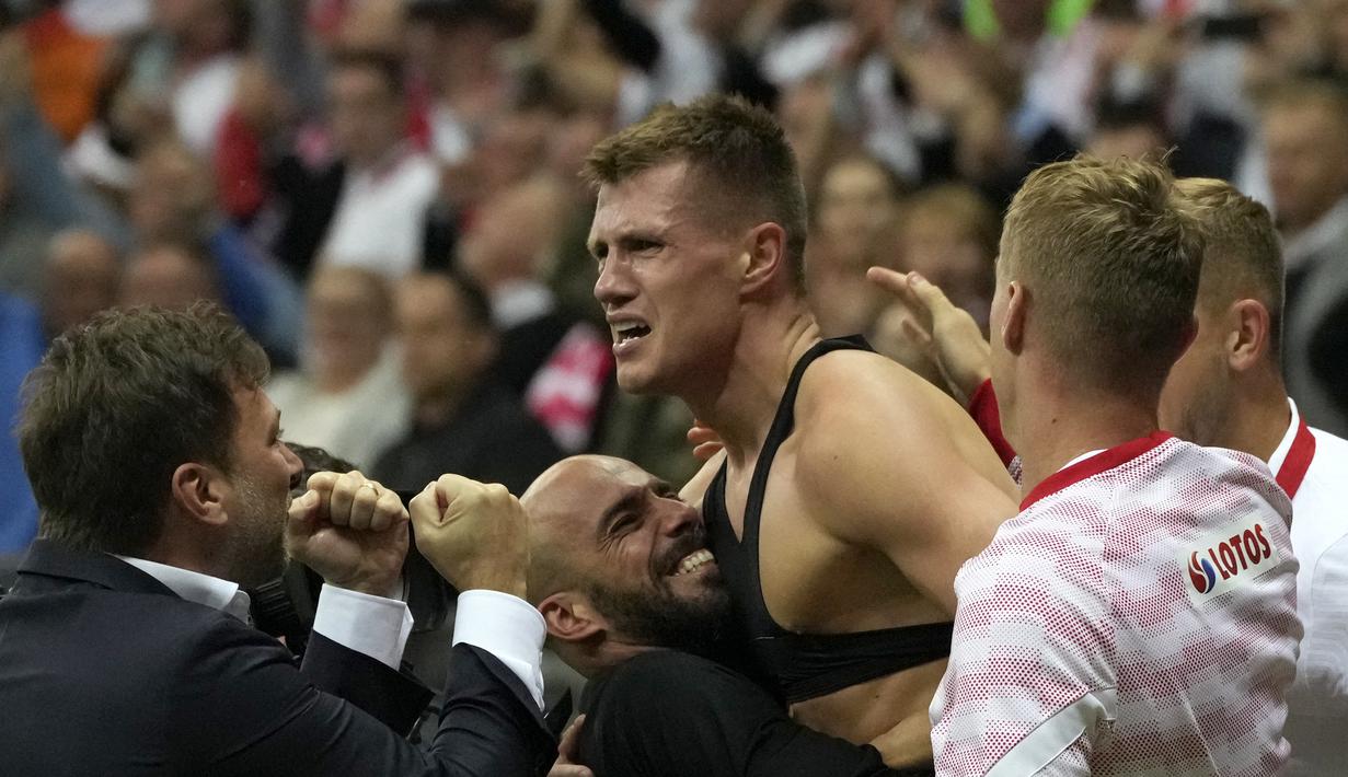 Pemain Polandia, Damian Szymanski (tengah) berselebrasi usai mencetak gol ke gawang Inggris pada pertandingan kualifikasi grup I Piala Dunia 2022 di stadion Narodowy di Warsawa, Kamis (9/9/2021). Inggris bermain imbang dengan Polandia 1-1. (AP Photo/Czarek Sokolowski)