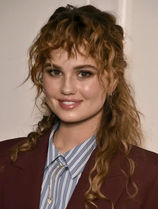 Debby Ryan tersenyum saat tiba menghadiri pemutaran perdana "Spin Me Round," di The London di West Hollywood, California (17/8/2022).  Debby Ryan tampil memesona dengan rambut ikalnya dengan anting di hidungnya. (Photo by Jordan Strauss/Invision/AP)