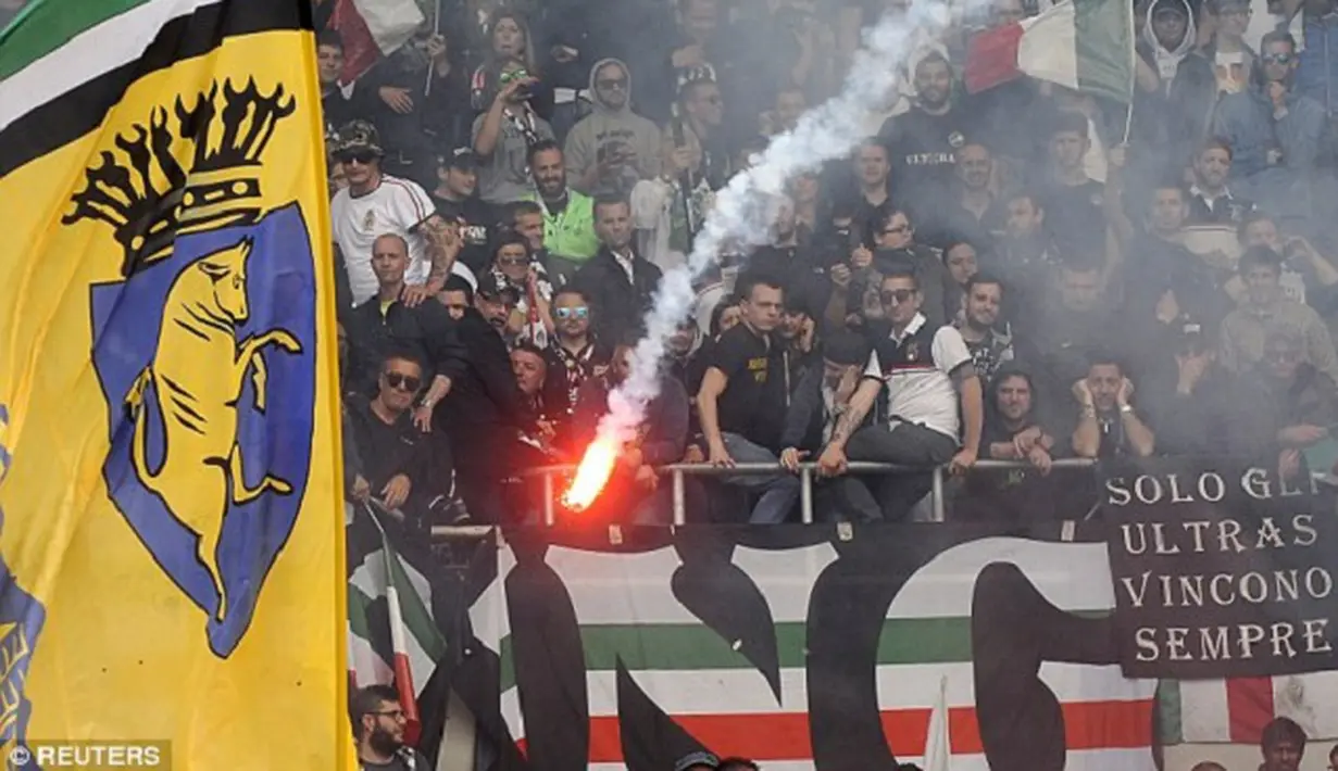 Sebuah suar menyala di stadion di mana sembilan penggemar dilaporkan terluka selama derby. (Dailymail)