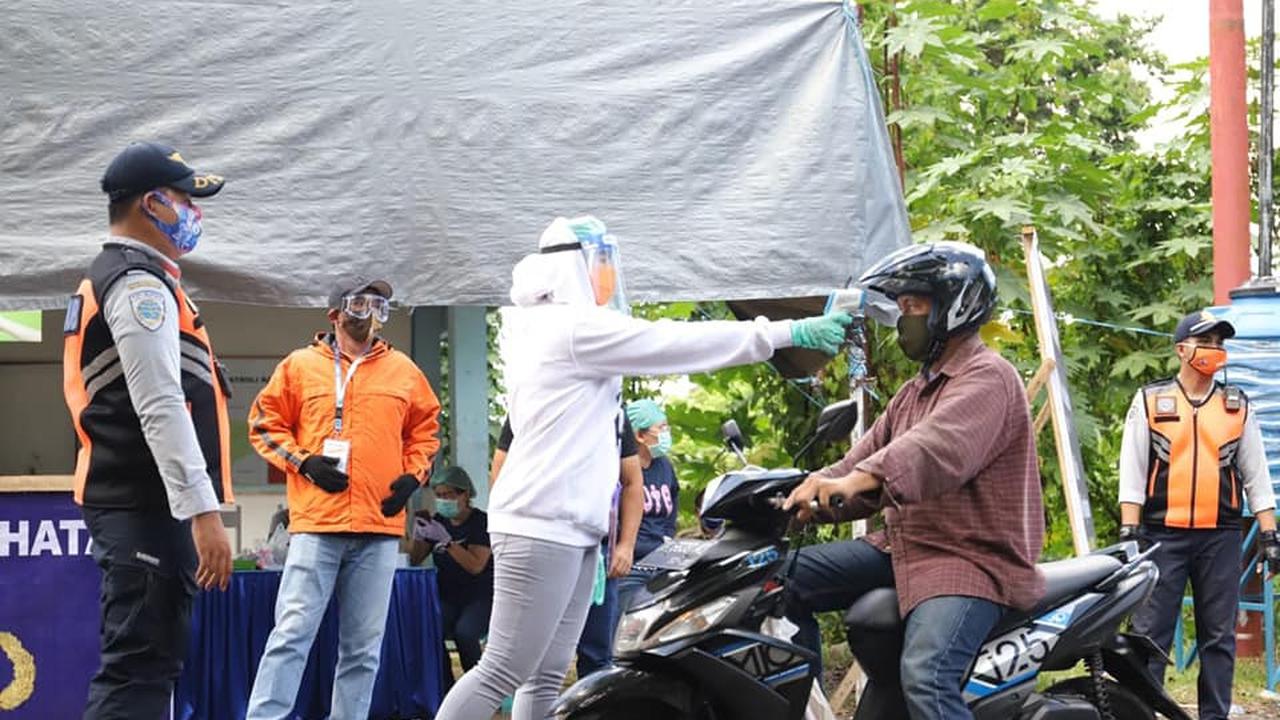 Upaya menghambat penyebaran Covid-19, tenaga medis memeriksa suhu tubuh warga yang akan masuk ke Kota Manado.