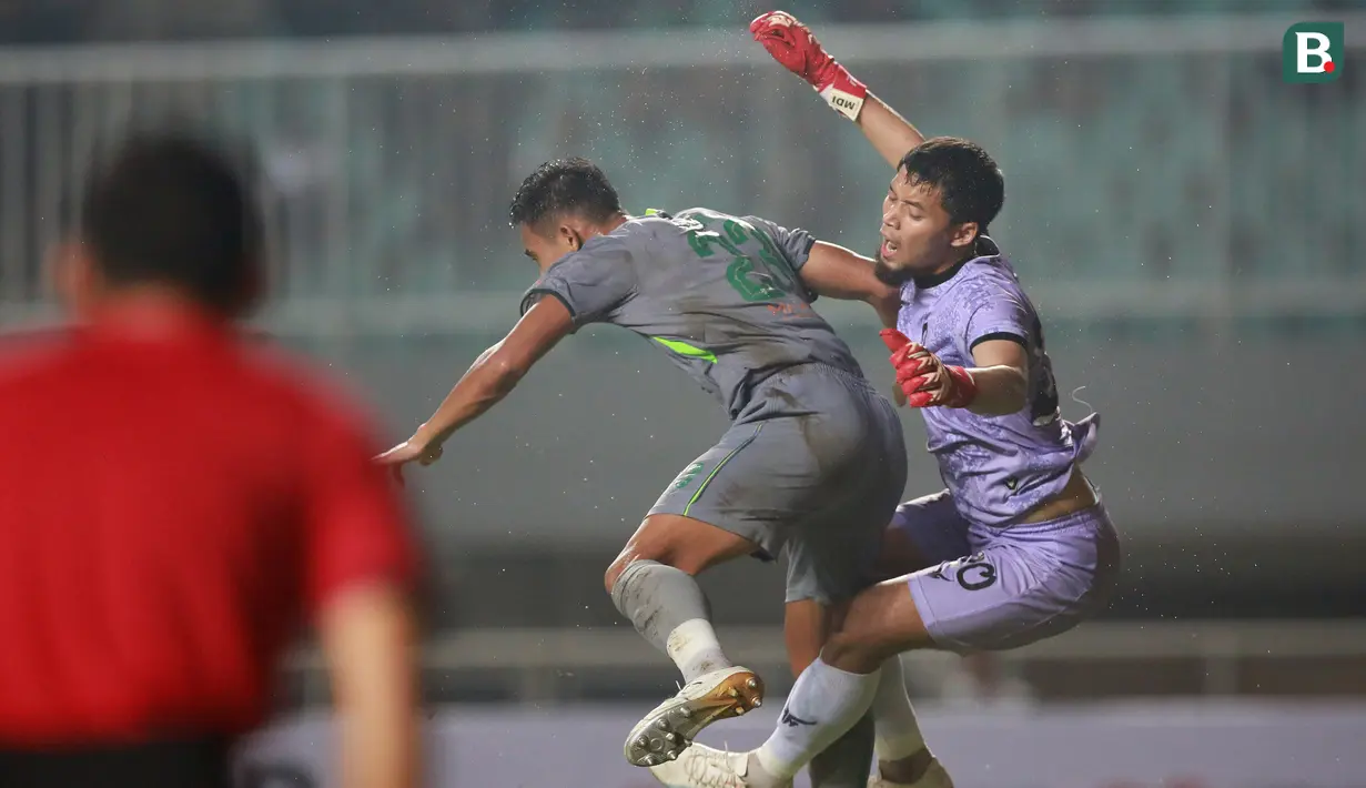 Kiper Persikabo 1973, Mochamad Diky Indriyana (kanan) berduel udara dengan pemain Persebaya Surabaya, Rizky Ridho Ramamadhani dalam laga pekan pertama BRI Liga 1 2022/2023 antara Persikabo 1973 melawan Persebaya Surabaya di Stadion Pakansari, Bogor, Senin (25/7/2022) malam WIB. (Bola.com/M Iqbal Ichsan)