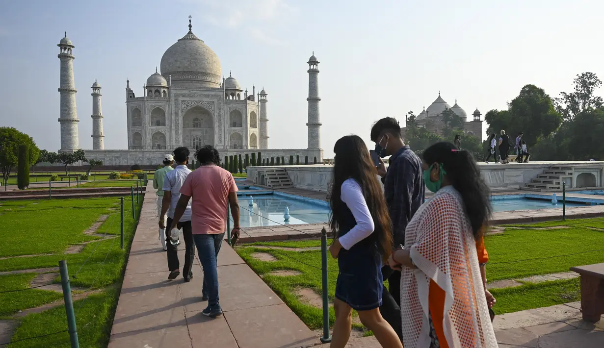 Turis mengunjungi Taj Mahal setelah dibuka kembali untuk pengunjung menyusul pelonggaran pembatasan virus corona Covid-19 di Agra, Inida, Rabu (16/6/2021). Taj Mahal ditutup untuk umum pada awal April 2021 ketika India memberlakukan tindakan penguncian ketat. (Money SHARMA/AFP)