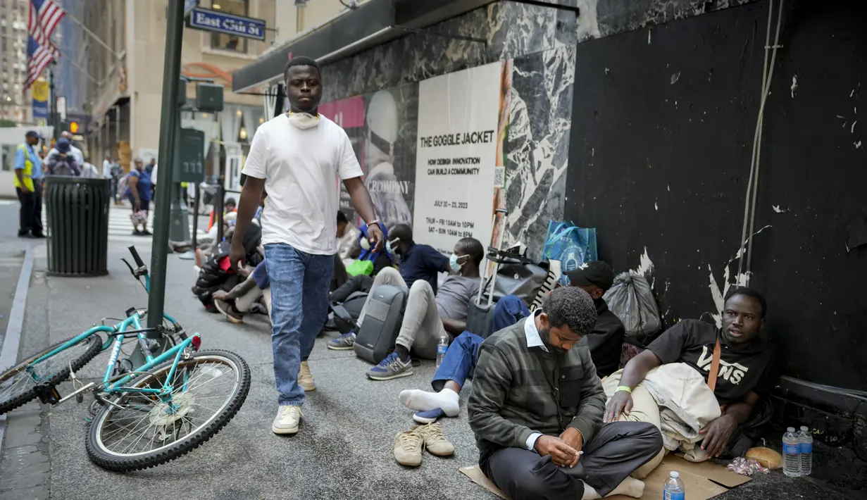 Migran yang baru tiba tertidur terlihat memenuhi trotoar di sekitar hotel bersejarah di 45th Street dan Vanderbilt Avenue, membentang dari pintu hotel hingga East 47th Street.  (AP Photo/John Minchillo)