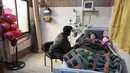 Gadis Suriah Sham Sheikh Mohammad (9) yang diselamatkan setelah empat puluh jam di bawah reruntuhan gempa Turki-Suriah yang mematikan, terbaring di ranjang rumah sakit di provinsi Idlib yang dikuasai pemberontak, pada 17 Februari 2023. Sham menderita crush syndrome, suatu kondisi yang berpotensi fatal yang menyebabkan amputasi anggota tubuh, merusak ginjal dan penyakit jantung. (Omar HAJ KADOUR / AFP)