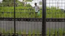 Suparno dari Posyantek (Pos Pelayanan Teknologi Tepat Guna) Kreya Loka RPTRA Belimbing, Pasar Minggu, menyemprotkan tanaman padi yang terserang hama, Kamis (22/10/2026). Inovasi menanam padi dalam galon ini dilakukan sebagai upaya mendukung ketahanan pangan di lingkungan permukiman. Program yang digagas Jaenab  berhasil menghasilkan sekitar 70 kilogram gabah dari 350 galon pada panen perdana Maret 2026. (KLY/Budy Santoso)