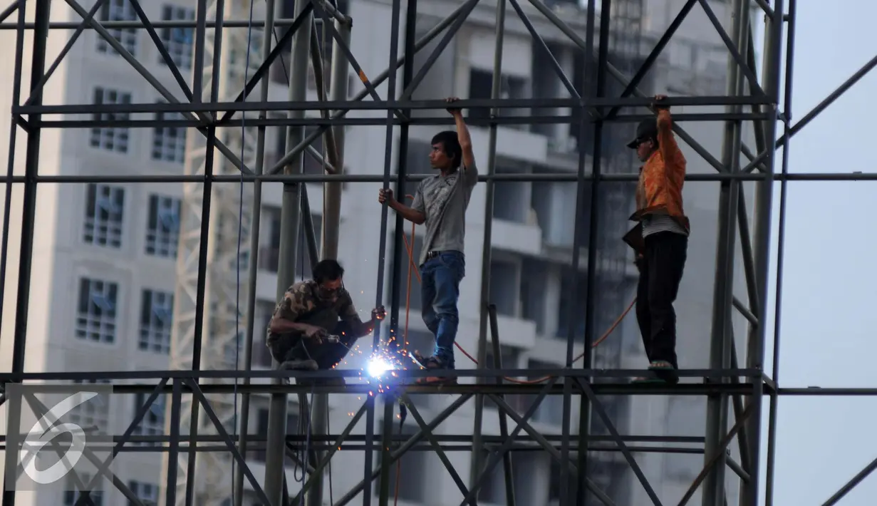 Pekerja mengelas rangkaian besi untuk pembuatan papan reklame di jalan Gadjah Mada, Jakarta, Selasa (13/12). Pemerintah DKI Jakarta akan menyusun rencana penataan terhadap reklame yang tidak beraturan di jalur protokol. (Liputan6.com/Gempur M. Surya)