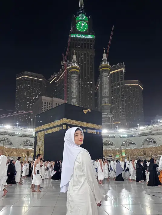 Berfoto di depan Ka'bah, Fuji mengenakan gamis dan kerudung putih yang dipermanis dengan bros. [Instagram/@fuji_an]