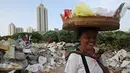 Seorang pedagang melintasi kawasan limbah bangunan yang digunakan Anak-anak bermain layang-layang di Gandaria, Jakarta, Jumat (4/3). (Liputan.com/Immanuel Antonius)