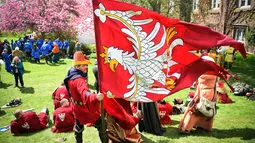 Seorang peserta memegang bendera timnya saat mengikuti kompetisi IMCF di Scone Palace, Perthshire, Skotlandia (10/5). Mereka bergaya dan menggunakan senjata yang dulu digunakan para kesatria untuk bertempur.  (AFP/Andy Buchanan)