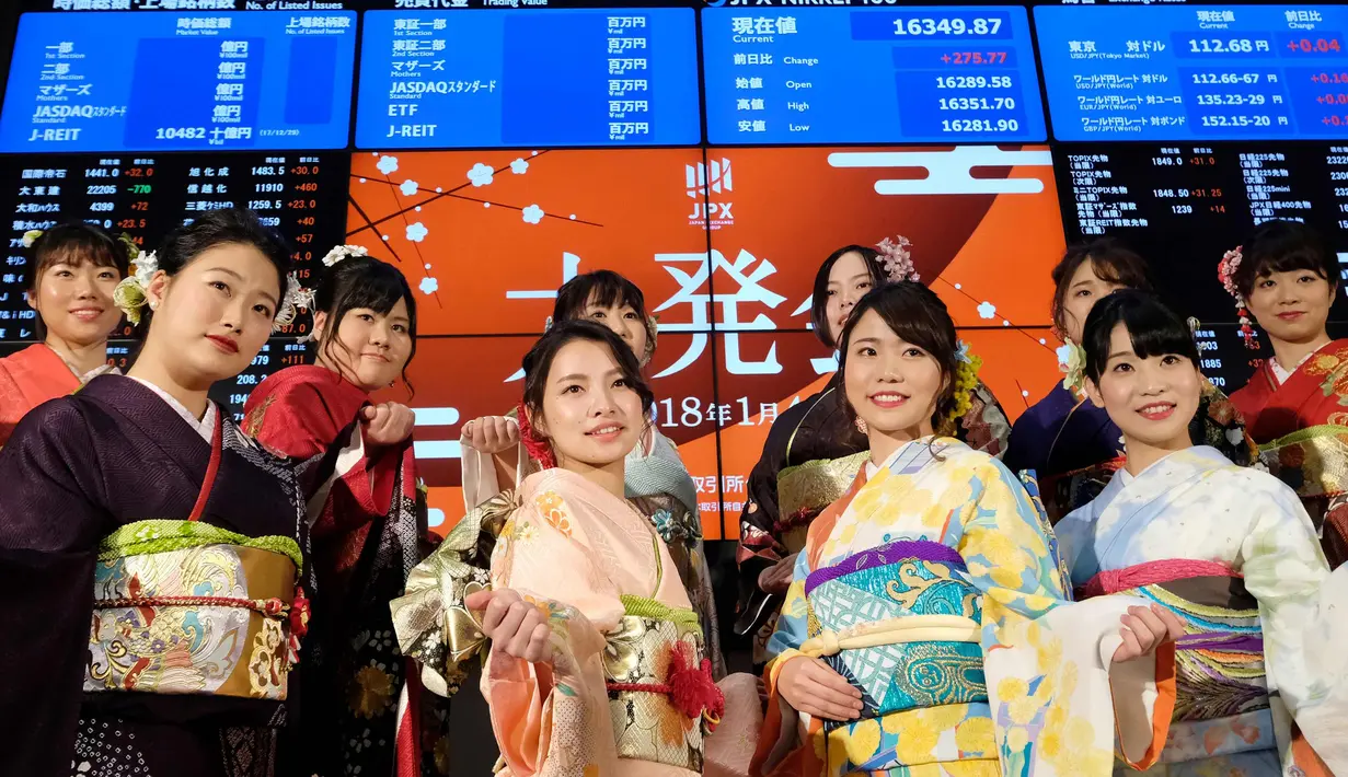 Sejumlah wanita mengenakan busana kimono berpose setelah pembukaan pasar saham untuk tahun ini di Bursa Saham Tokyo, Jepang (4/1). Mereka hadir sebagai bagian dari upacara pembukaan bursa saham yang digelar setiap awal tahun. (AP Photo/Eugene Hoshiko)