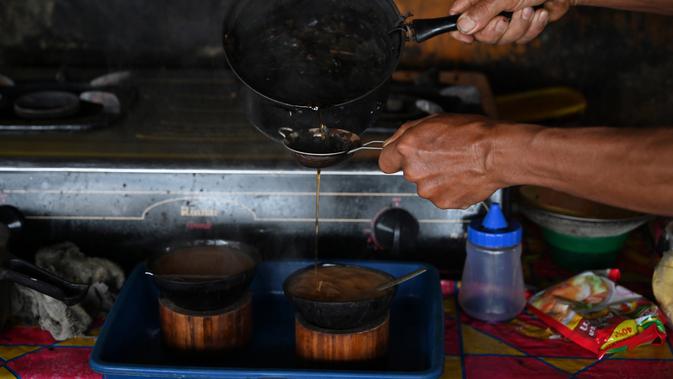 Seorang pria membuat kopi Kawa Daun di sebuah kafe tradisional, Tabek, Sumbar (29/11). Kopi Kawa Daun adalah minuman kuno yang berasal dari masa kolonial ketika sedikit penduduk setempat yang mampu membeli kopi yang diekstrak. (AFP Photo/Adek Berry)