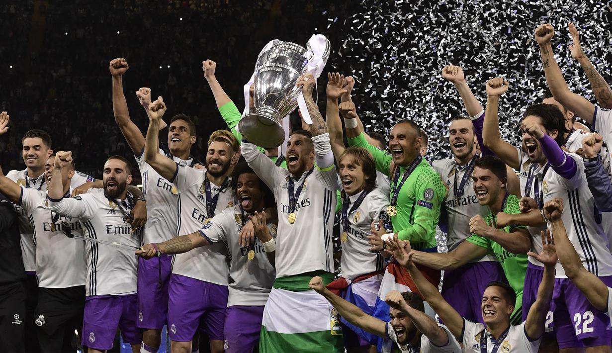 Kapten Real Madrid, Sergio Ramos, mengangkat piala merayakan gelar juara Liga Champions bersama rekan-rekannya di Stadion Millenium, Cardiff, Sabtu (3/6/2017). Madrid menang 4-1 atas Juventus. (AFP/Javier Soriano)