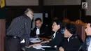 Mantan hakim Mahkamah Konstitusi (MK) Patrialis Akbar (kiri) berbincang dengan kuasa hukumnya saat menjalani sidang tuntutan di Pengadilan Tipikor, Jakarta, Senin (14/8). Patrialis Akbar dituntut 12 tahun 6 bulan penjara. (Liputan6.com/Helmi Fithriansyah)
