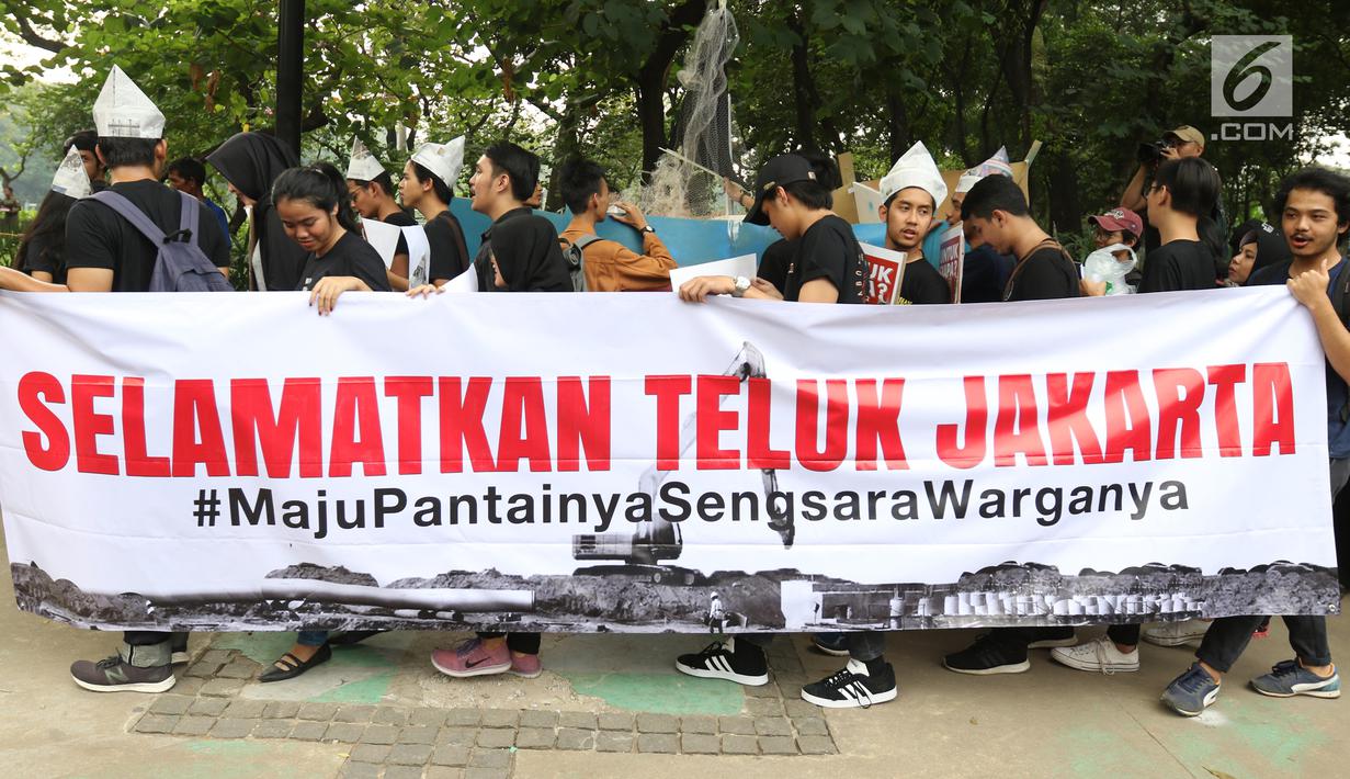 Massa yang tergabung dalam Koalisi Selamatkan Teluk Jakarta menggelar aksi jalan mundur menuju Balai Kota di Jakarta, Senin (24/6). Dalam aksinya mereka meminta kepada Gubernur DKI Jakarta untuk mencabut kembali keputusan penerbitan IMB di Pulau C dan D reklamasi Teluk Jakarta. (Liputan6.com/Angga Y