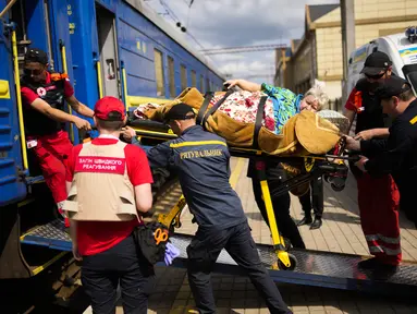 Seorang pasien dibawa dengan tandu untuk menaiki kereta evakuasi medis yang dijalankan oleh MSF (Doctors Without Borders) di stasiun kereta api di Pokrovsk, Ukraina timur, Minggu (29/5/2022). Kereta tersebut dilengkapi dikelola oleh tenaga medis, dan mengangkut pasien dari rumah sakit yang kewalahan di dekat garis depan, ke fasilitas medis di Ukraina barat, jauh dari pertempuran. (AP Photo/Francisco Seco)