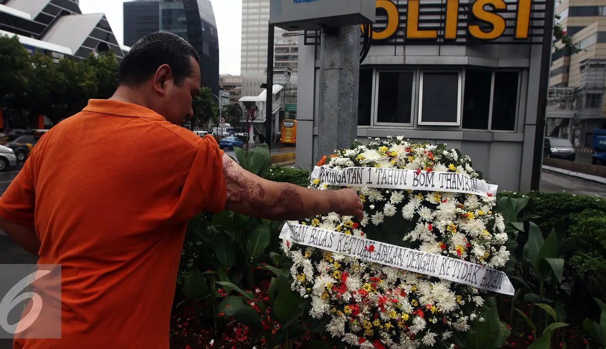 Polisi Korban Bom Thamrin Aiptu Denny Maheu, malakukan tabur bunga saat aksi damai "Peringatan 1 Tahun Tragedi Bom Thamrin 14 Januari 2016", di TKP Pos Polisi Perempatan Sarinah, Jalan Thamrin, Jakarta, Sabtu (14/1). (Liputan6.com/JohanTallo)