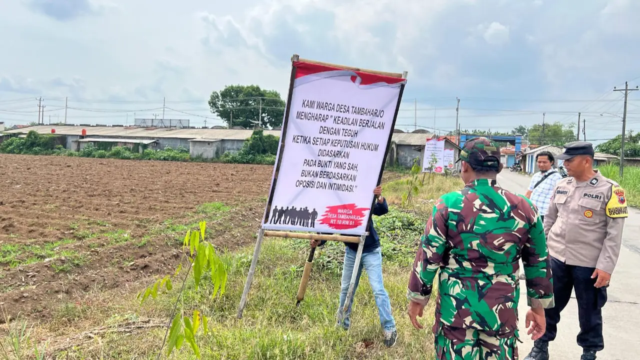 Pihak aparat gabungan mencopot spanduk sebagai upaya meredam saling klaimnya dua desa di Pati.