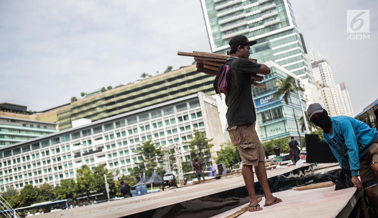 Pekerja menyelesaikan pembuatan panggung HUT ke-492 DKI di area Bundaran HI, Jakarta, Kamis (20/6/2019). HUT ke-492 DKI akan dimeriahkan dengan acara Jakarta Night Festival dan Jakarta Creative Night. (Liputan6.com/Faizal Fanani)
