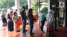 Warga antre menggunakan ATM Pertanian Si Komandan untuk mendapatkan beras gratis di Kodim 0606/Kota Bogor, Jawa Barat, Minggu (26/4/2020). Kementerian Pertanian bersama Bank BNI, dan TNI AD  menempatkan ATM beras gratis di sejumlah Kodim di wilayah Jabodetabek. (merdeka.com/Arie Basuki)