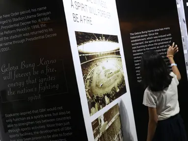 Dua orang anak melihat-lihat dokumentasi pembangunan kompleks olahraga Gelora Bung Karno yang dipamerkan di area Stadion GBK, Jakarta, Rabu (29/8). Sejumlah dokumentasi pembangunan stadion dicetak dan bisa dilihat warga. (Liputan6.com/Helmi Fithriansyah)