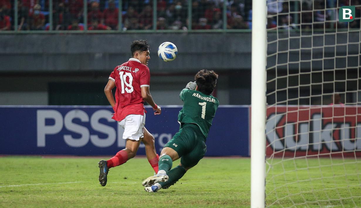 <p>Pemain Timnas Indonesia U-19,&nbsp;Marcell Januar Putra (kiri)&nbsp;&nbsp;berusaha memasukan bola ke gawang Thailand yang dijaga Narongsak Naengwongsa dalam pertandingan babak penyisihan Grup A Piala AFF U-19 yang berlangsung di Stadion Patriot Candrabhaga, Bekasi, Rabu (6/7/2022). (Bola.com/Bagaskara Lazuardi)</p>