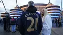 Seorang fans Manchester City memakai jaket bertuliskan "CHAMPIONS 21" merayakan keberhasilan timnya memastikan merebut gelar juara Liga Inggris 2020/2021 di luar Etihad Stadium, Selasa (11/5/20221) sesaat setelah kekalahan Manchester United 1-2 oleh Leicester City di Old Trafford. (AP/Jon Super)