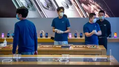 Para pekerja mengenakan masker saat menjaga Apple Store yang dibuka kembali di Beijing, China, Jumat (14/2/2020). Apple kembali membuka tokonya di China setelah pada awal Februari lalu menutup seluruhnya karena khawatir terhadap wabah virus corona. (AP Photo/Mark Schiefelbein)