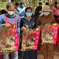 Penduduk desa Kamboja memegang poster untuk menyebarkan kesadaran akan flu burung. Seorang gadis meninggal akibat infeksi H5N1 manusia pertama yang diketahui sejak 2014. (AP)
