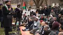 Warga Muslim mendengarkan ceramah saat menggelar Salat Jumat berjamaah di depan Gedung Putih, Jumat (8/12). Para warga muslim ini menggelar sajadah mereka di sebuah taman yang ada di depan kediaman resmi Presiden AS Donald Trump. (mari matsuri / AFP)