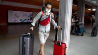 Seorang turis Rusia tiba di Bandara Internasional Bali, Jumat (4/2/2022). Bali kembali dibuka untuk pelancong asing dari semua negara setelah penerbangan internasional dilanjutkan untuk pertama kalinya dalam dua tahun, tapi pengunjung tetap wajib karantina. (AP Photo/Firdia Lisnawati)