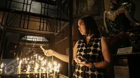 Umat Kristiani menyalakan lilin ketika memanjatkan doa mengikuti misa malam Natal di Gereja Katedral, Jakarta, Kamis (24/12). Perayaan Natal 2015 mengangkat tema "Hidup Bersama Sebagai Keluarga Allah". (Liputan6.com/Faizal Fanani)