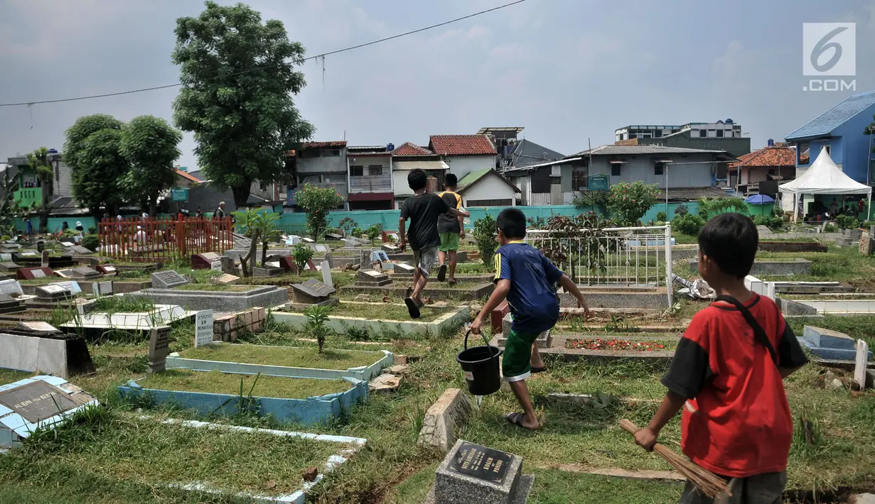 Anak-anak usai membersihkan makam di TPU Cipinang Baru, Jakarta, Minggu (5/5/2019).  Anak-anak yang mayoritas masih duduk di sekolah dasar ini biasanya melayani jasa Ngoret secara berkelompok dengan tugas masing-masing seperti menyapu dan membersihkan sekitar makam. (merdeka.com/Iqbal S. Nugroho)