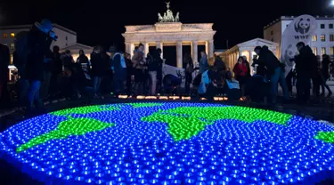 Sejumlah lilin dinyalakan dan dibentuk seperti dunia sebelumnya aksi Earth Hour Internasional di Berlin, Jerman (25/3). Kegiatan ini dilakukan dalam rangka memperingati hari bumi atau lebih dikenal dengan Earth Hour ke-10 atau 2017. (AFP/dpa/Paul Zinken)