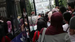 Warga terlihat berdesakan untuk menaiki bus tingkat wisata di Halte Bundaran HI, Jakarta, Kamis (1/1/2015). (Liputan6.com/Faizal Fanani)