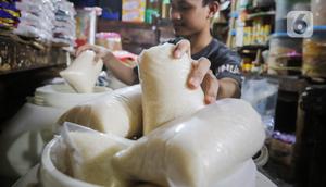 Seorang pedagang menimbang gula pasir di Pasar Kebayoran Lama, Jakarta, Selasa (21/11/2023). (Liputan6.com/Angga Yuniar)