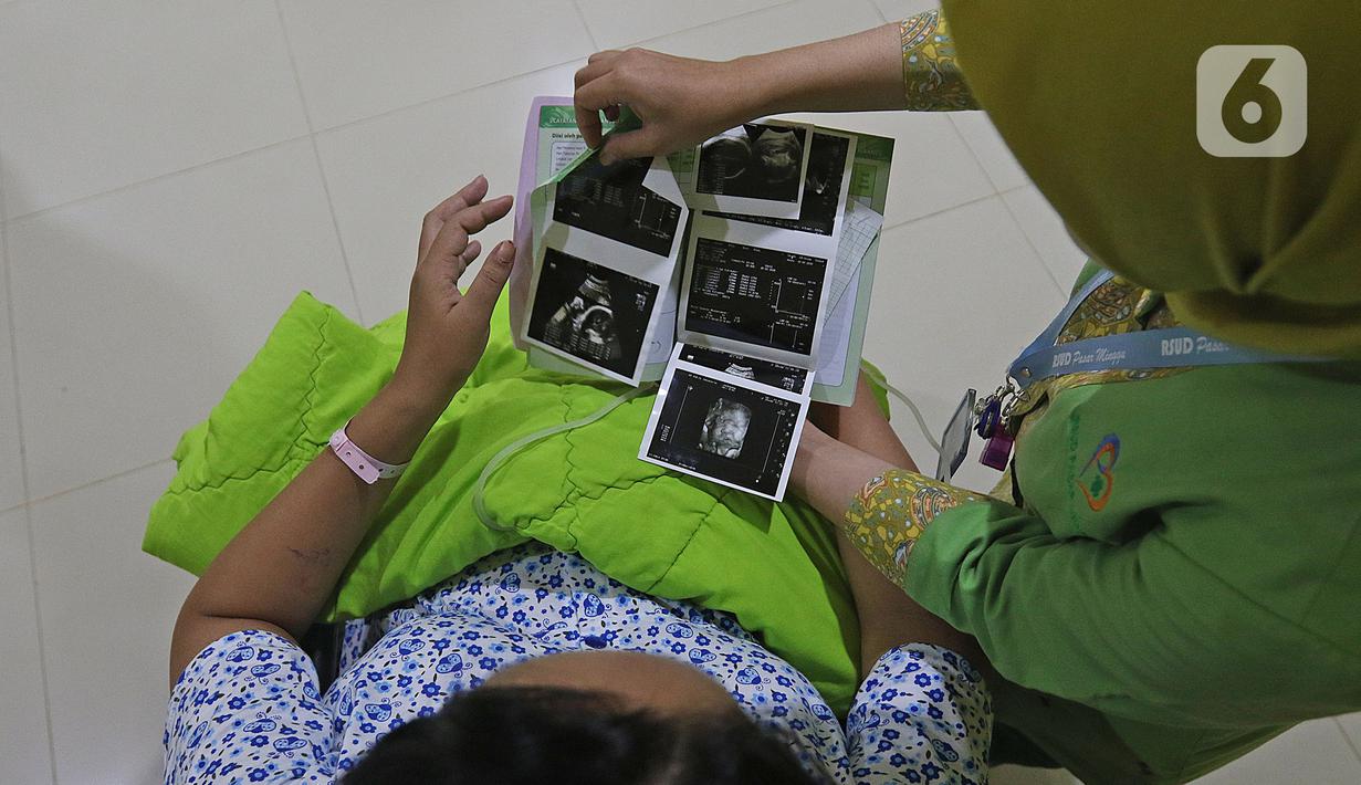 Suster menunjukkan hasil USG kandungan dari Regina (43) yang akan menjalani proses persalinan di RSUD Pasar Minggu, Jakarta, Kamis (20/2/2020). Bayi perempuan dari pasangan Regina dan Andre (47) lahir secara sesar di tanggal 20 bulan 02 tahun 2020 atau 20-02-2020. (Liputan6.com/Herman Zakharia)