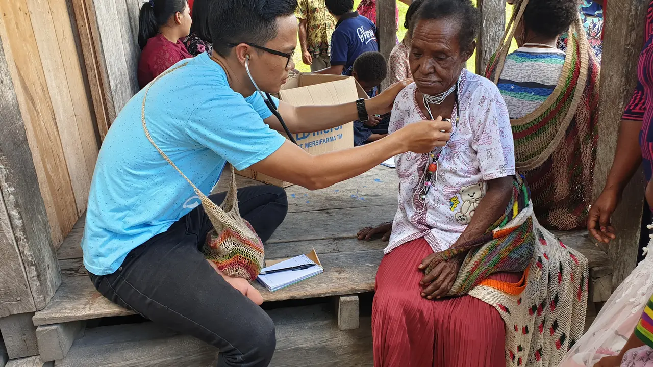 Dokter Yandry Pamangin tengah memeriksa pasien.